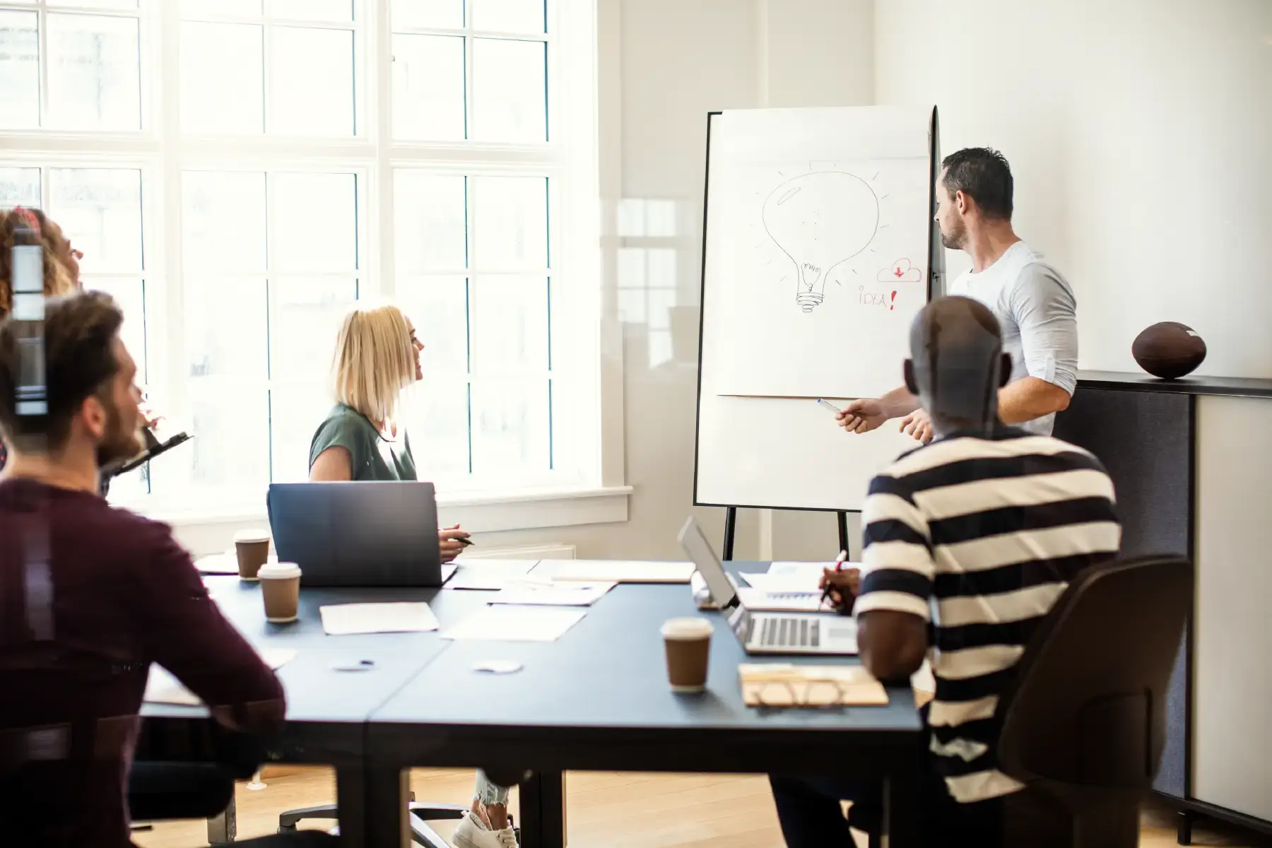 Strategic workshop session with professionals collaborating around a whiteboard — representing brand consulting in action