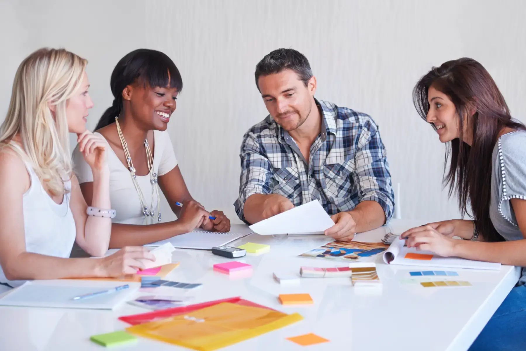 Creative agency team reviewing colour palettes and brand strategy in a collaborative planning session, symbolising ambition for global repositioning