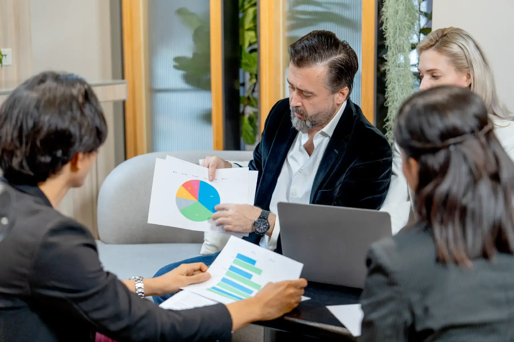 Finance professionals reviewing charts and data in a collaborative office environment