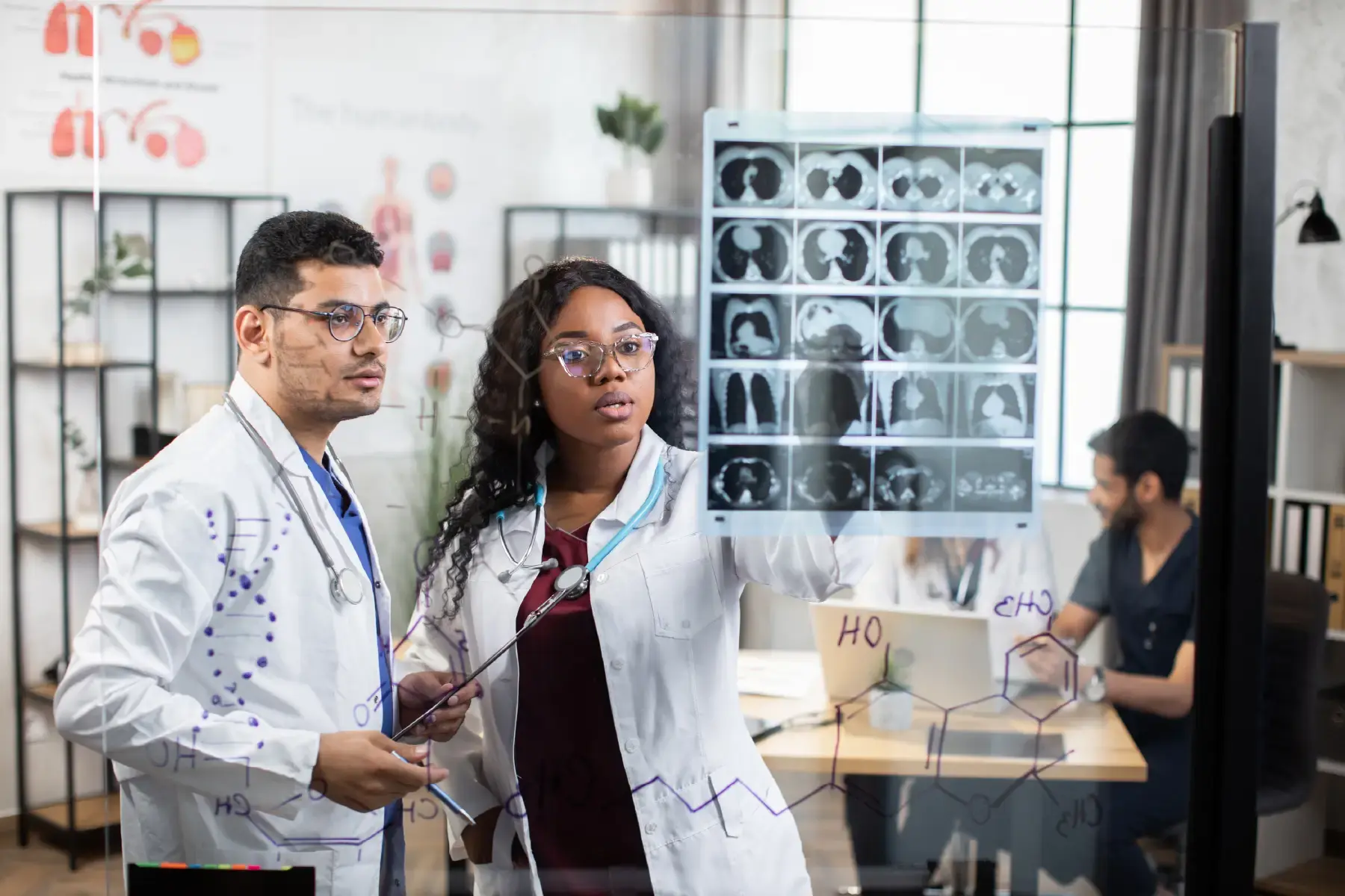 Doctors discussing diagnostic imagery in a hospital setting, representing innovation and coordination in healthcare delivery