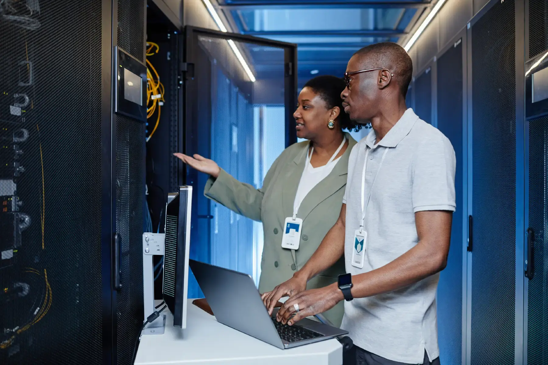 IT professionals analysing server data in a modern data centre, representing infrastructure reliability and managed services