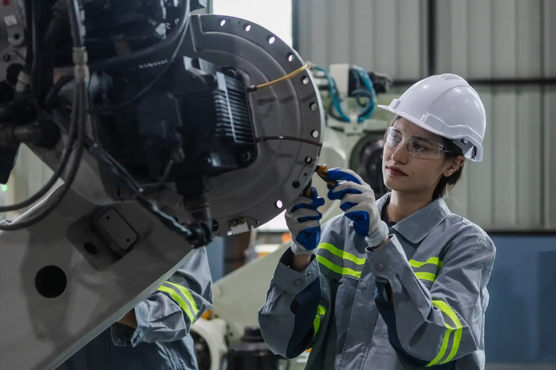Industrial technicians inspecting large-scale manufacturing machinery in a factory environment
