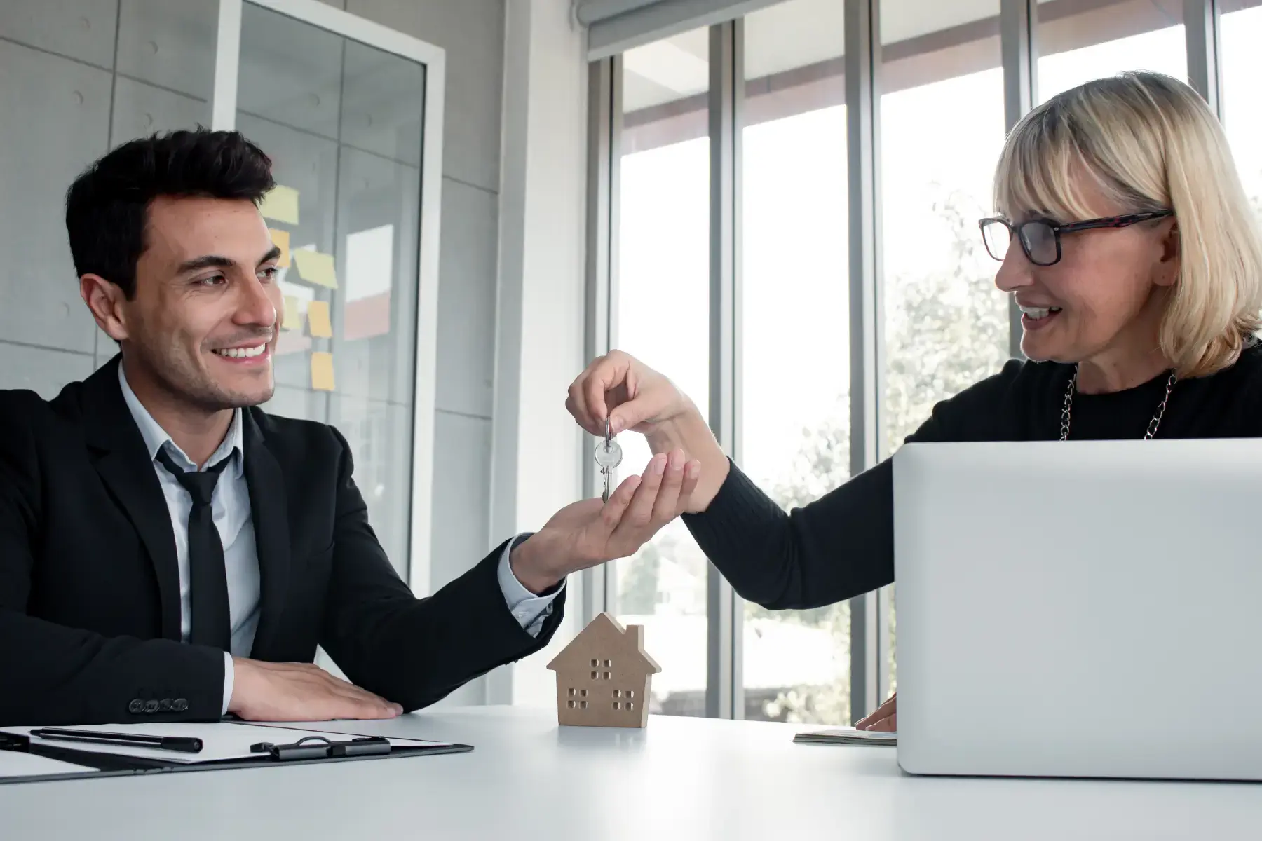 Real estate advisor shaking hands with a client in a bright office setting, symbolising trust and investment