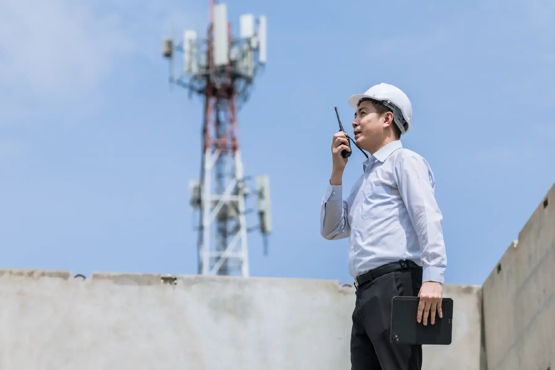 Telecommunications engineer inspecting signal tower equipment, representing the infrastructure behind modern connectivity