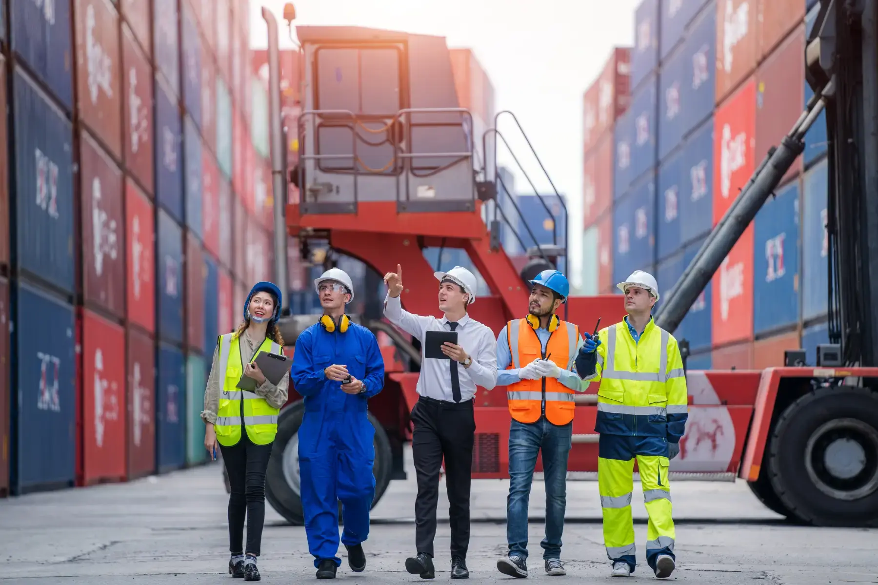 Logistics professionals coordinating operations at a busy port with stacked shipping containers in the background